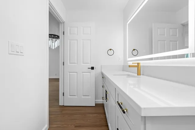 a bathroom with a double vanity sink a mirror and bathtub