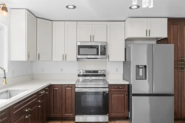 a kitchen with refrigerator a microwave a stove and cabinets