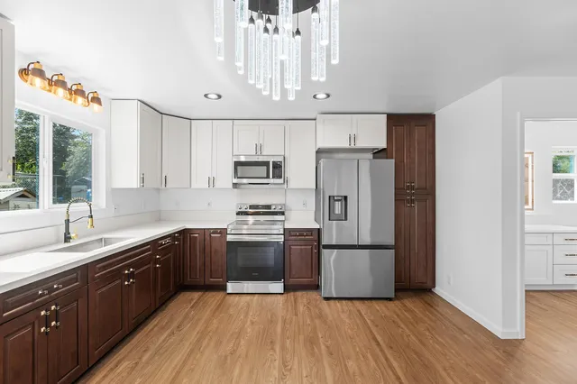 a kitchen with stainless steel appliances a refrigerator sink and cabinets