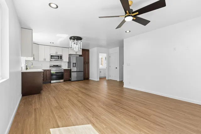 a view of a kitchen with wooden floor and a ceiling fan