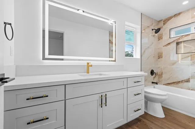 a bathroom with a double vanity sink mirror and toilet