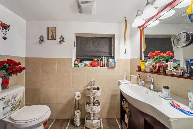 a bathroom with a sink mirror vanity and toilet
