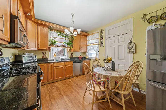 a kitchen with stainless steel appliances kitchen island granite countertop a stove a sink and a refrigerator