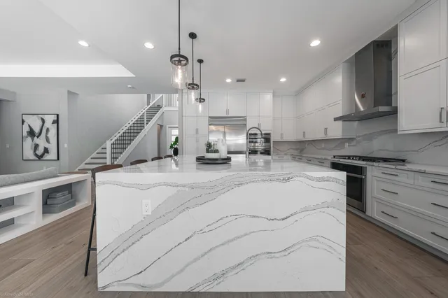 a living room with furniture a wooden floor and a chandelier
