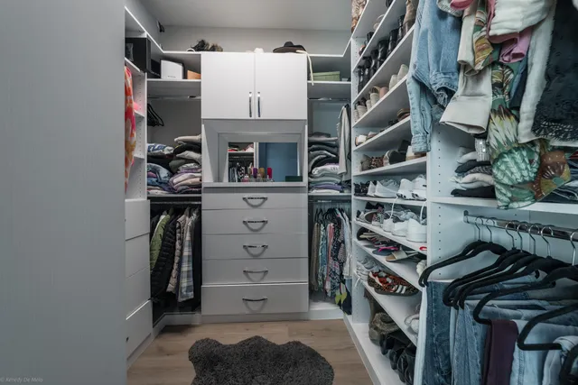 a view of walk in closet with clothes and shoes
