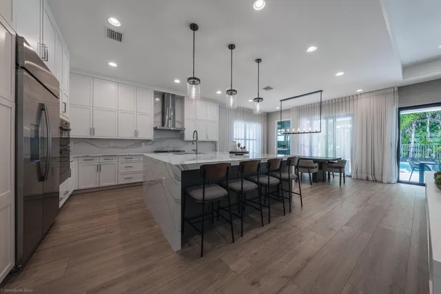 a large kitchen with stainless steel appliances lots of counter space and wooden floor