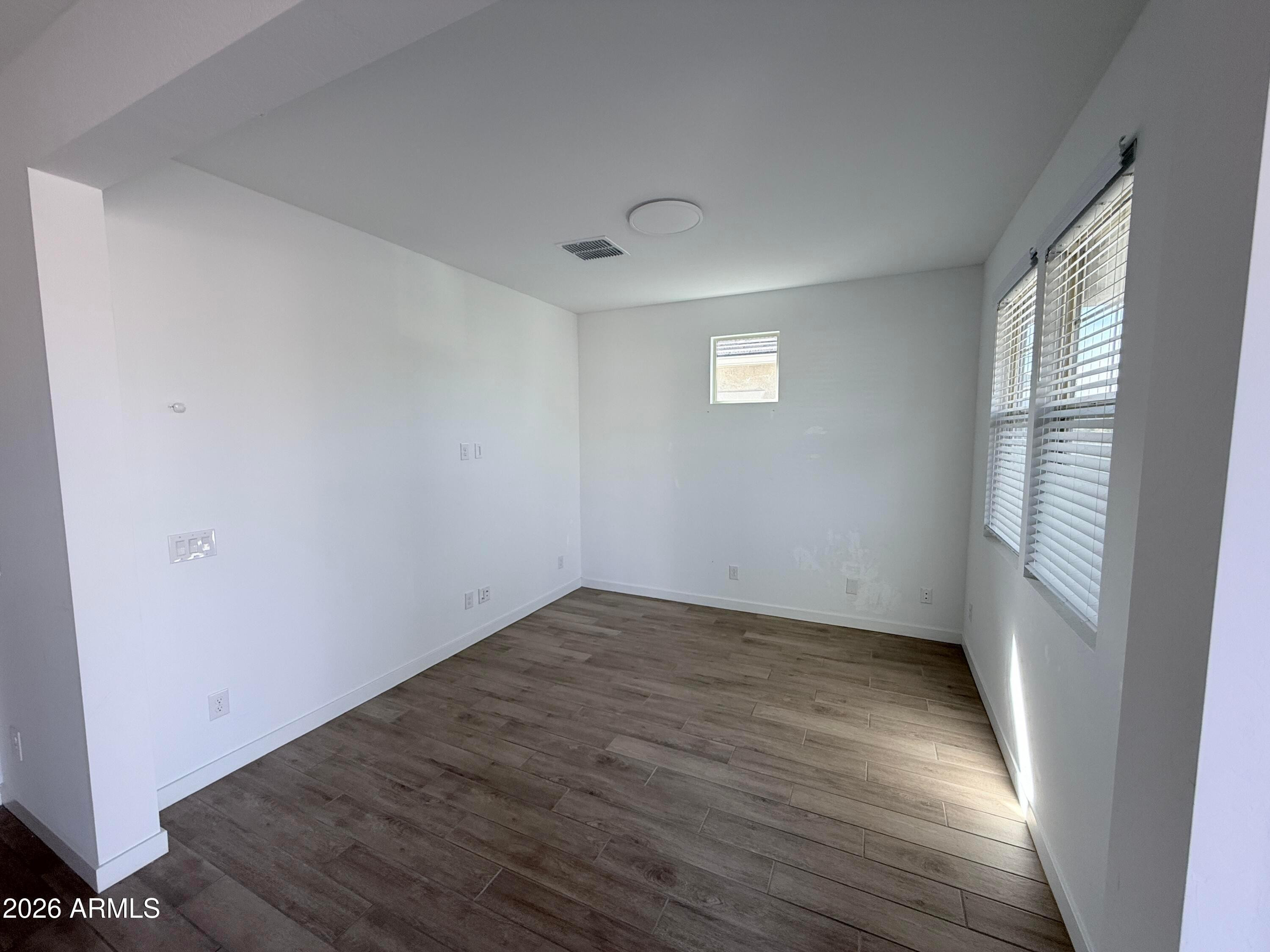 4323 West Palace Sta Road New River, AZ 85087 - Photo 4 of 20 an empty room with wooden floor and windows