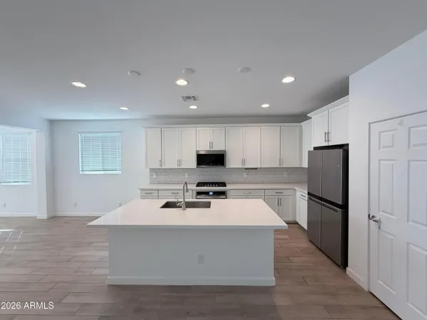 a kitchen with stainless steel appliances a refrigerator sink and microwave