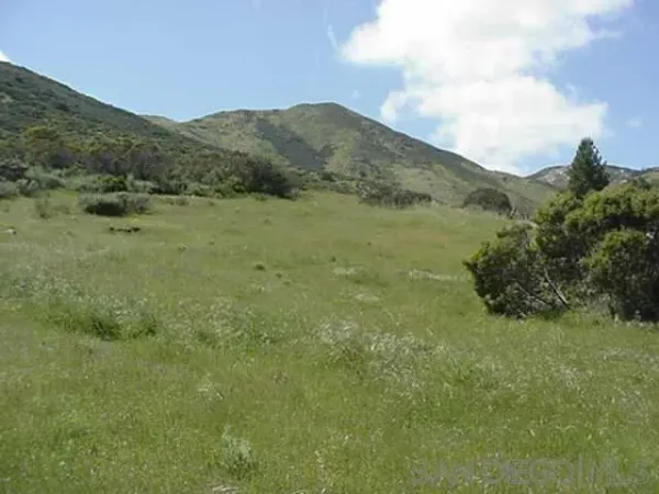 a view of a large mountain with mountains in the background