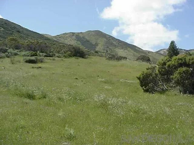 a view of a large mountain with mountains in the background