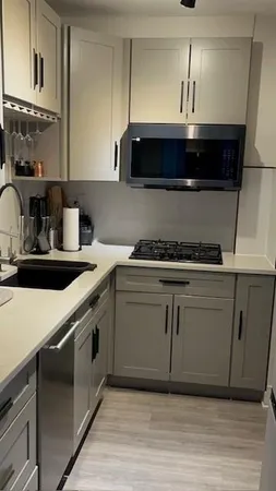a kitchen with stainless steel appliances a sink stove and cabinets