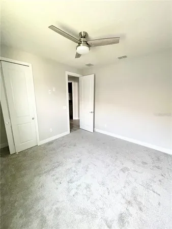 an empty room with a ceiling fan and a window