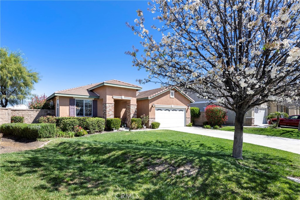 Lushly landscaped front yard with mature tree and oversized driveway!