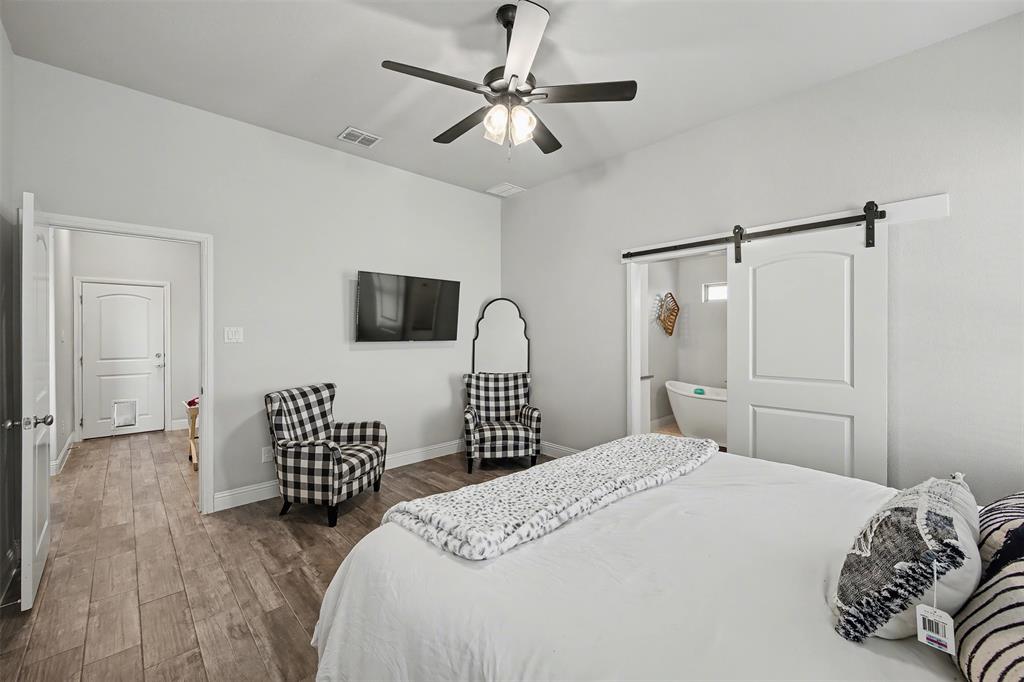 6334 Rustic Edge Street Godley, TX 76044 - Photo 11 of 26 a bedroom with a bed and a flat screen tv