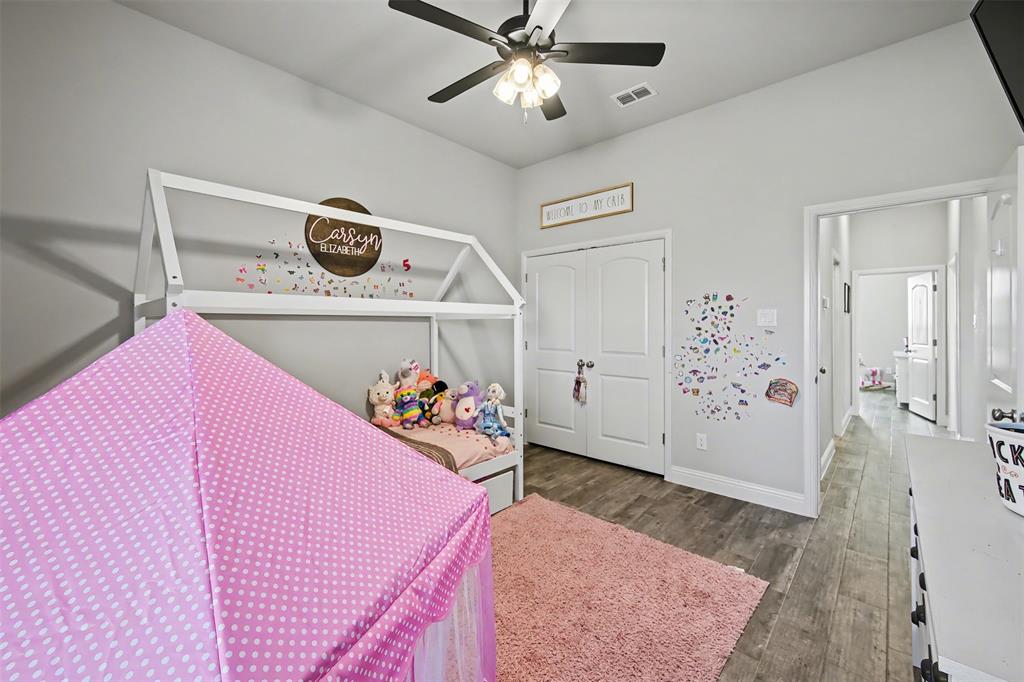 6334 Rustic Edge Street Godley, TX 76044 - Photo 17 of 26 a bedroom with a bed and wooden floor