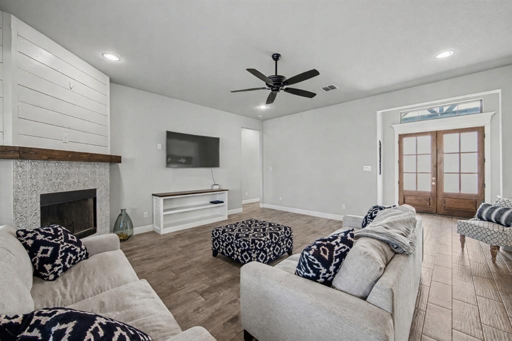 6334 Rustic Edge Street Godley, TX 76044 - Photo 6 of 26 a living room with furniture a fireplace and a flat screen tv