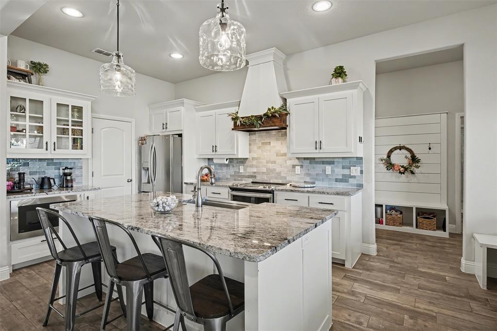 6334 Rustic Edge Street Godley, TX 76044 - Photo 8 of 26 a kitchen with stainless steel appliances granite countertop a stove and refrigerator