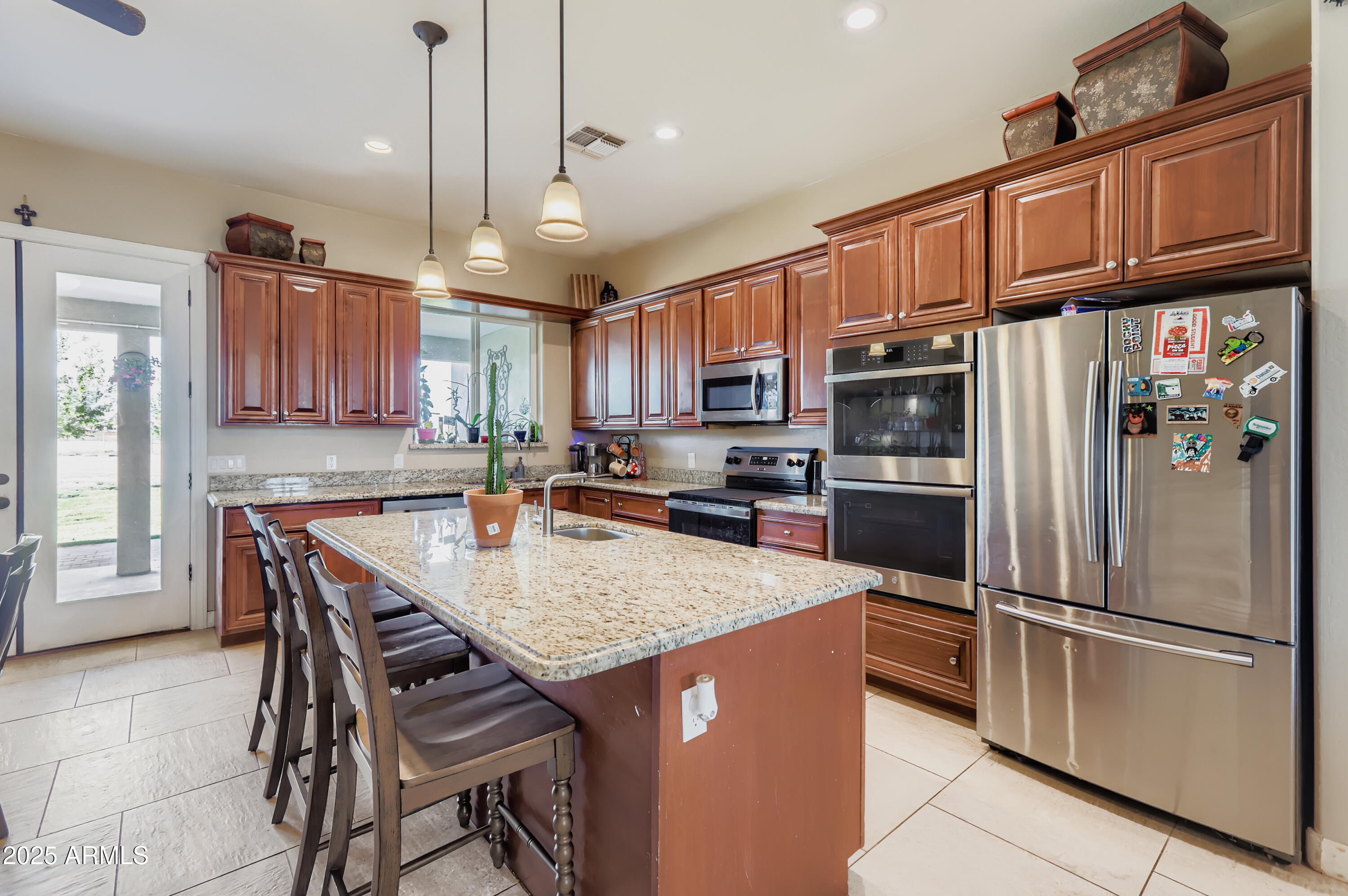22136 West Gambit Trail Wittmann, AZ 85361 - Photo 11 of 38 a kitchen with granite countertop a refrigerator a stove a sink and a center island