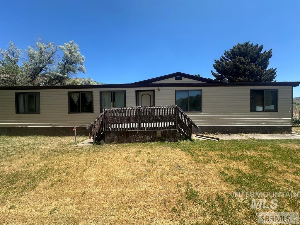 View of front of home with a front yard and a deck