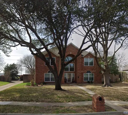 a tree in front of a white house