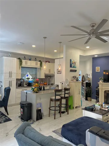 a living room with furniture a fireplace and a view of kitchen