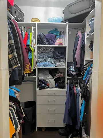 a view of walk in closet with clothes