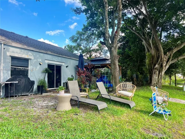 a view of a house with backyard porch and sitting area