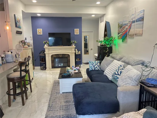 a living room with furniture mirror and a fireplace