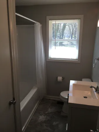 a bathroom with a toilet tub and sink