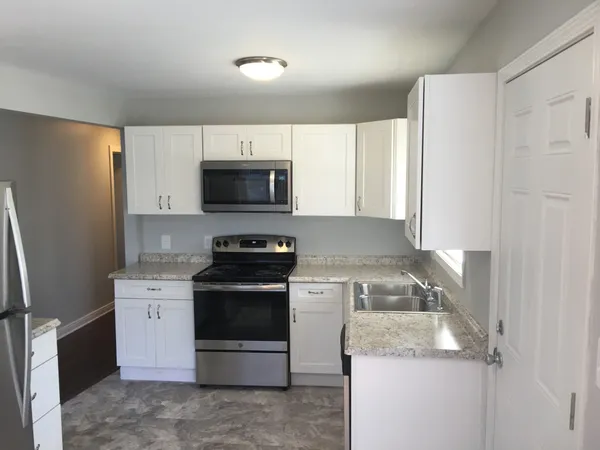 a kitchen with a sink stove and microwave