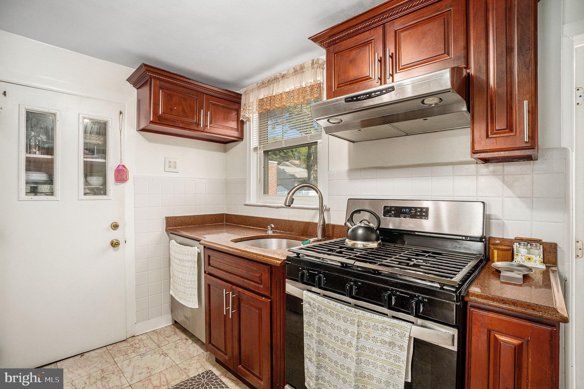 2209 East County Line Road Ardmore, PA 19003 - Photo 11 of 28 a kitchen with stainless steel appliances granite countertop a stove and a sink
