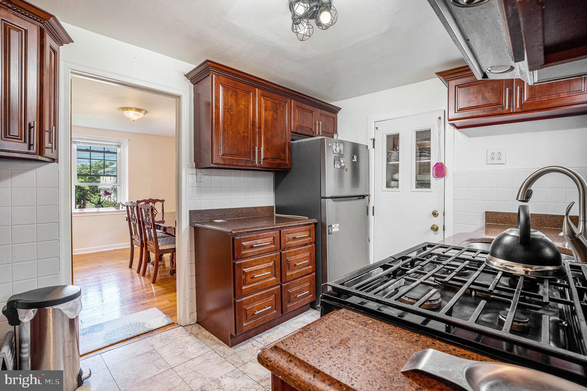 2209 East County Line Road Ardmore, PA 19003 - Photo 12 of 28 a kitchen with wooden cabinets and a stove top oven