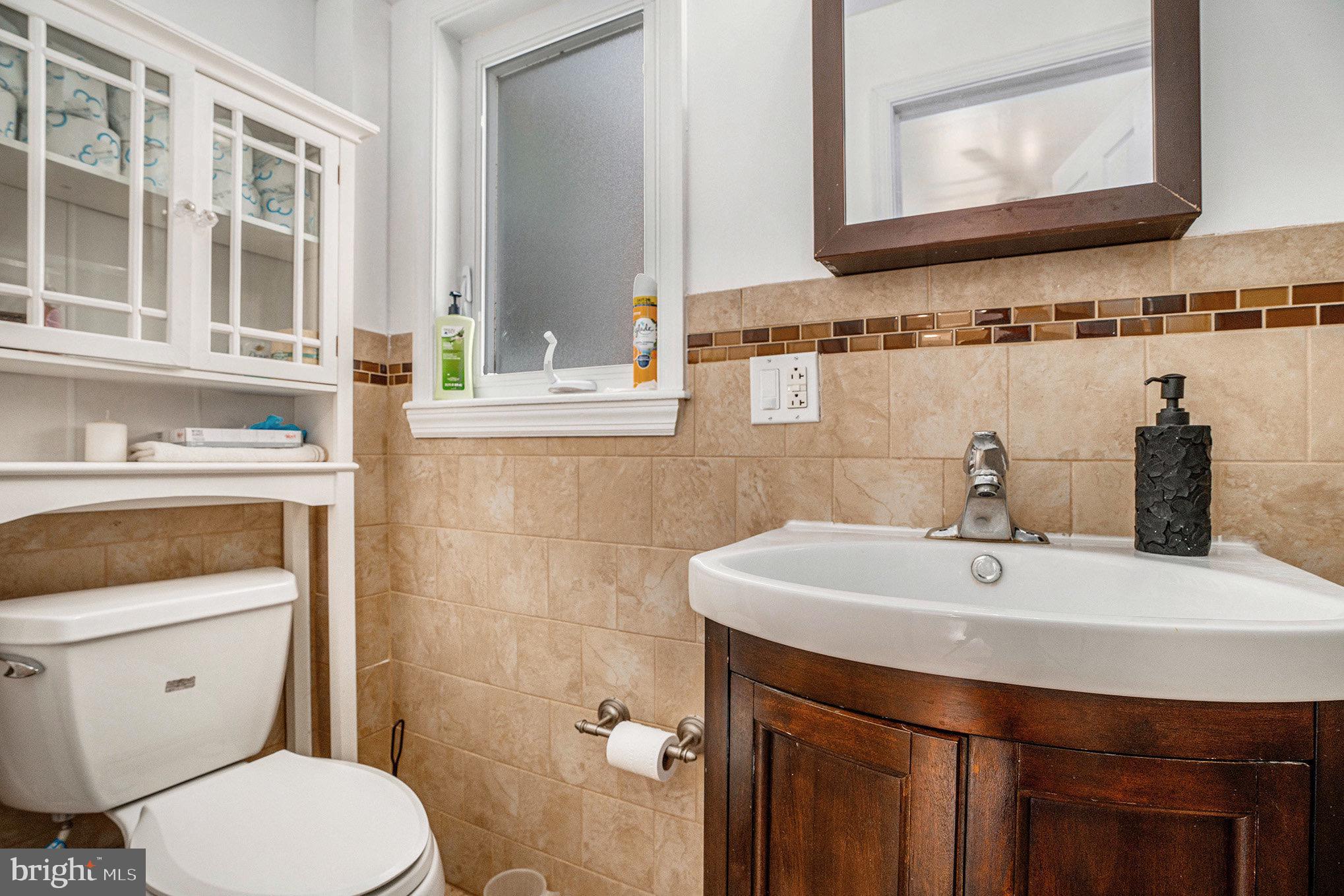 2209 East County Line Road Ardmore, PA 19003 - Photo 21 of 28 a bathroom with a sink a toilet and mirror