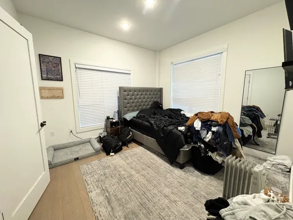 a bed room with a bed a mirror and a lamp