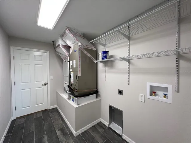 a hallway with white cabinets and white appliances