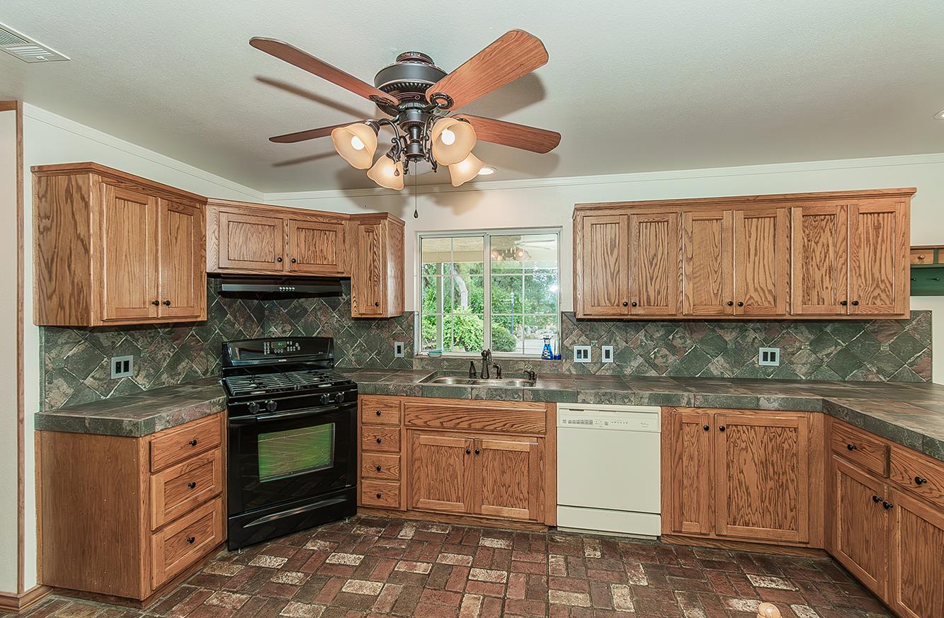 15501 Garlock Lane Prather, CA 93651 - Photo 11 of 47 a kitchen with stainless steel appliances granite countertop a stove sink microwave and cabinets