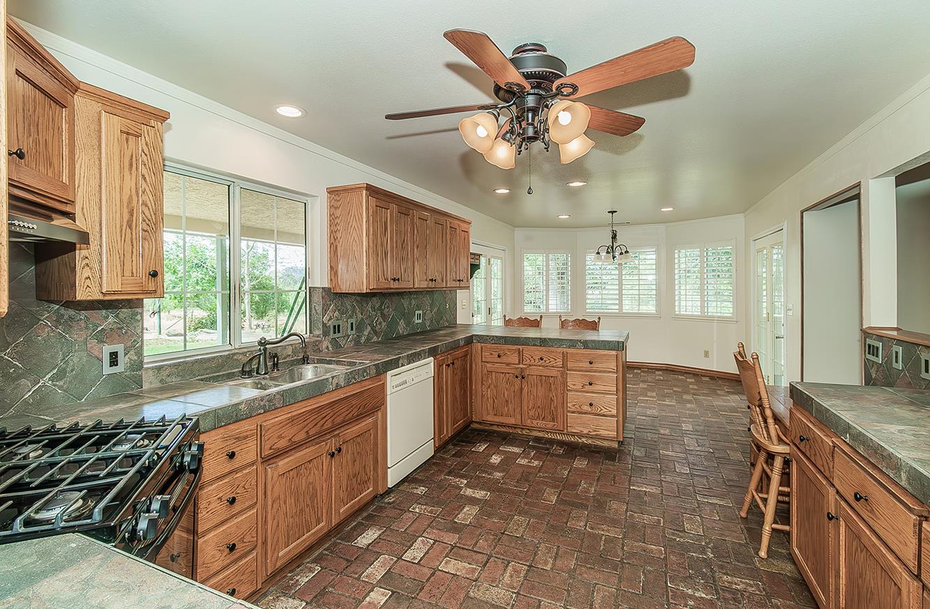 15501 Garlock Lane Prather, CA 93651 - Photo 12 of 47 a large kitchen with stainless steel appliances granite countertop a sink and cabinets