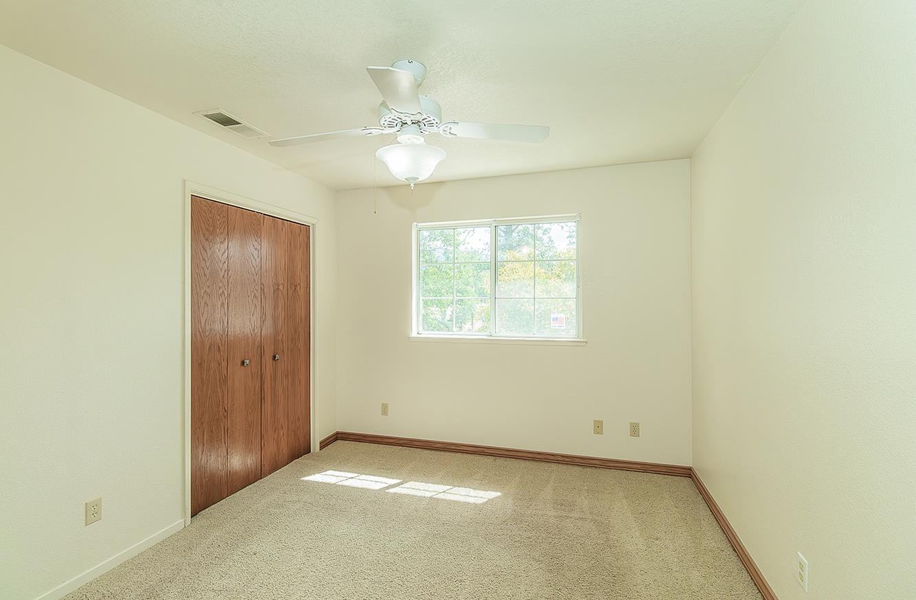15501 Garlock Lane Prather, CA 93651 - Photo 20 of 47 an empty room with a chandelier fan and windows