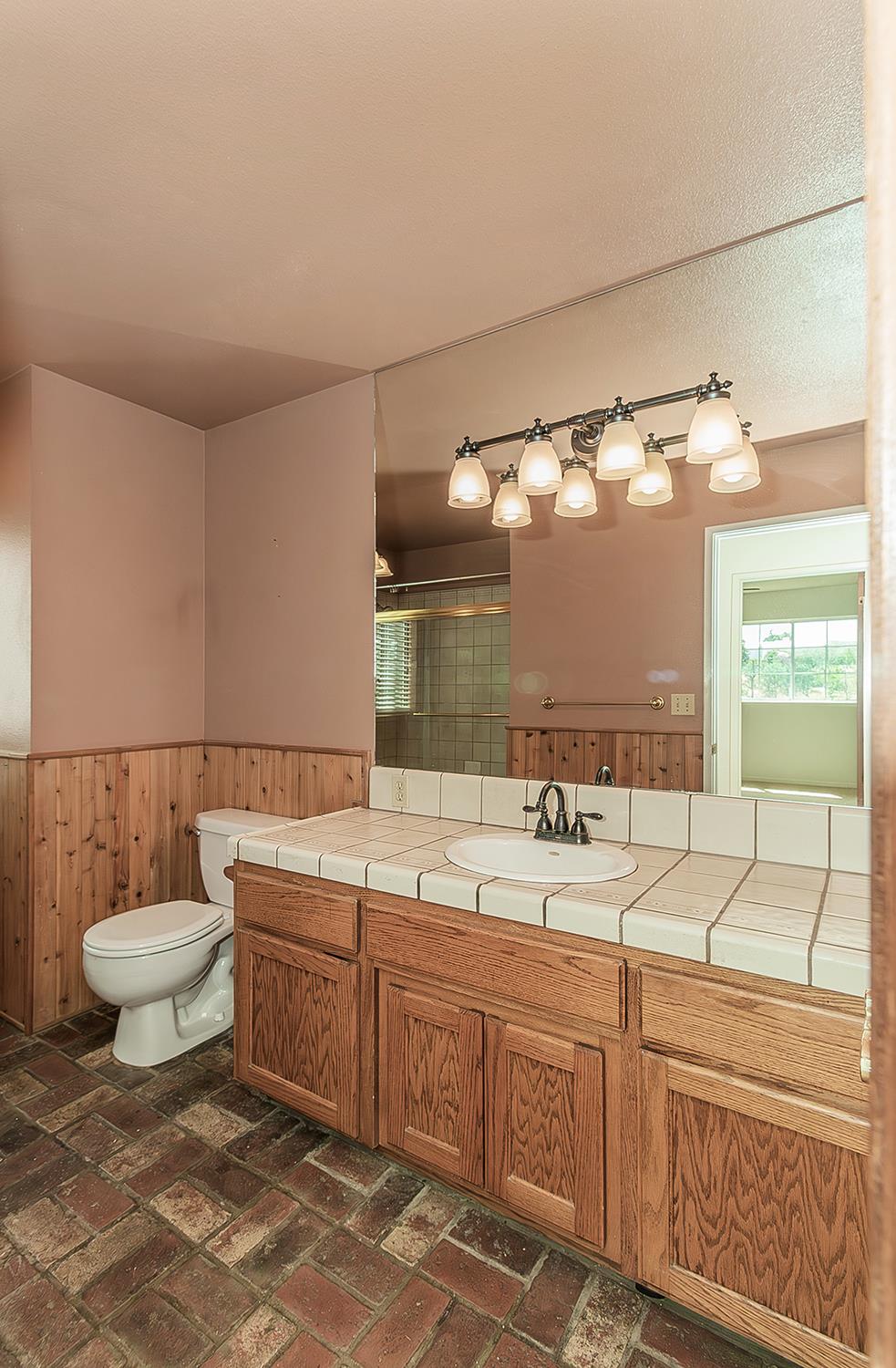 15501 Garlock Lane Prather, CA 93651 - Photo 22 of 47 a bathroom with a double vanity sink and a toilet