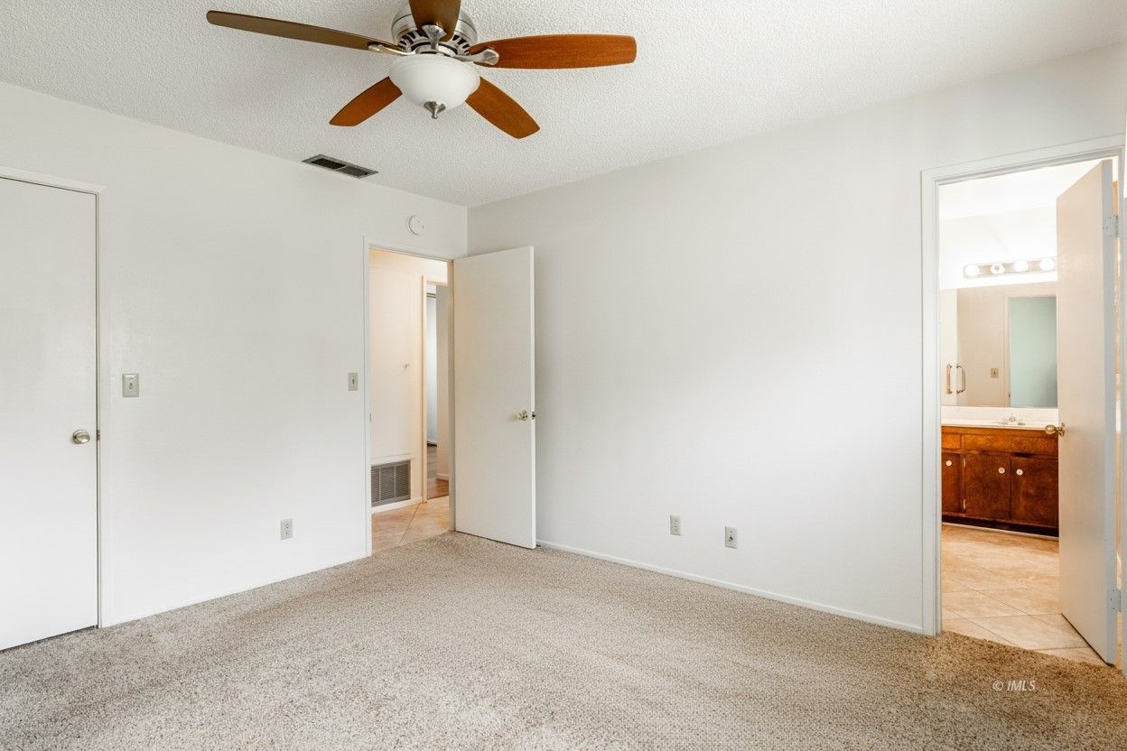 1424 Rocking W Drive Bishop, CA 93514 - Photo 12 of 27 an empty room with chandelier fan and windows