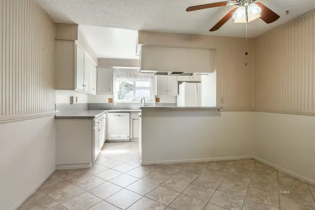 a kitchen with a sink window and cabinets