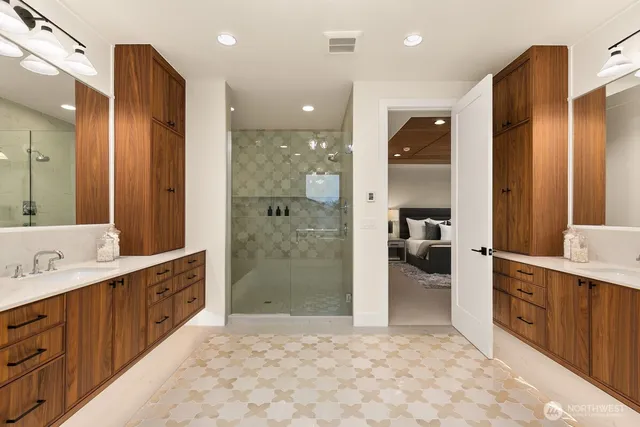 a bathroom with a sink a large mirror and a shower