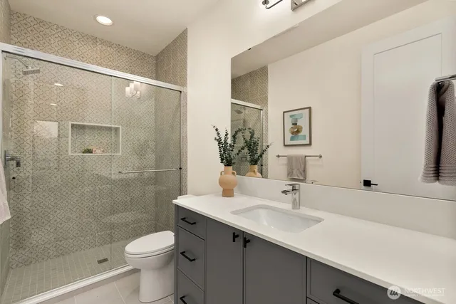 a bathroom with a sink a toilet and shower