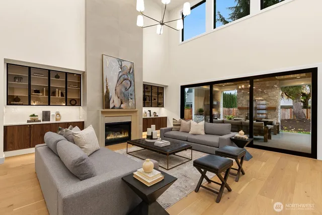 a living room with furniture a fireplace and a floor to ceiling window