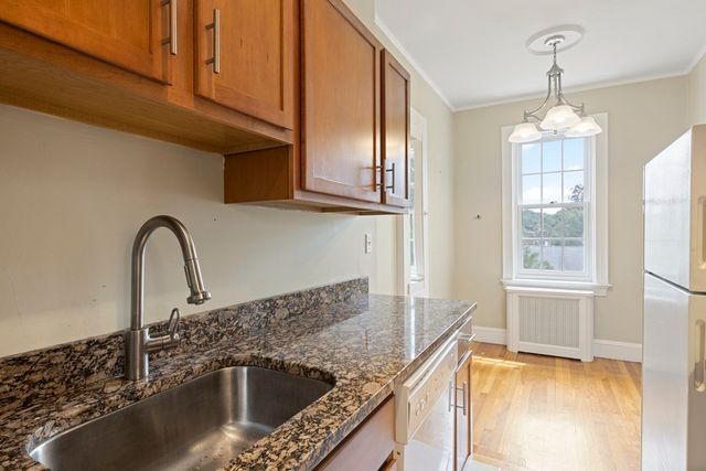 a kitchen with granite countertop a sink stainless steel appliances cabinets and a counter top space