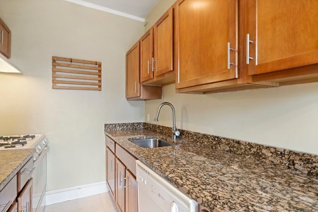 a kitchen with stainless steel appliances granite countertop a sink and a stove