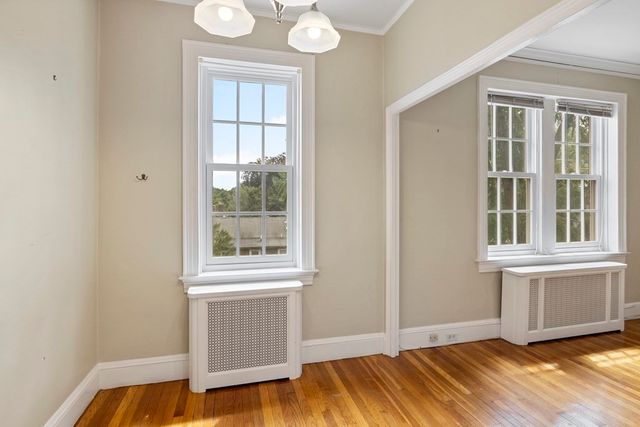 a view of a room with wooden floor and windows