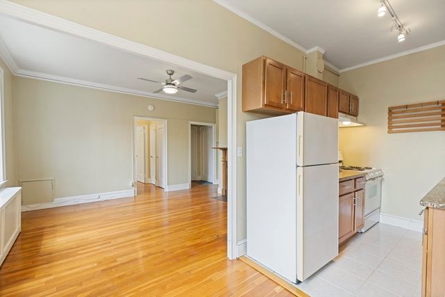 a white refrigerator freezer and a stove sitting inside of a kitchen