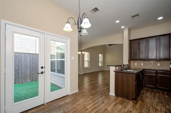 a kitchen with stainless steel appliances granite countertop a sink a stove and a wooden floors