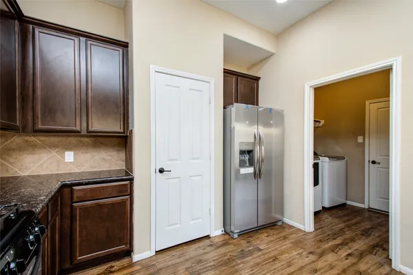 a view of a kitchen with wooden floor and electronic appliances
